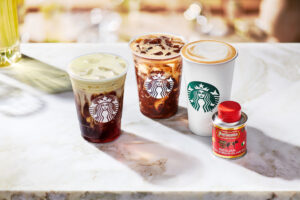 Three Starbucks Oleato beverages to go with small can of Partanna extra virgin olive oil on a marble countertop