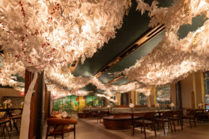 Starbucks interior festooned with white paper decorations of tree branches and leaves