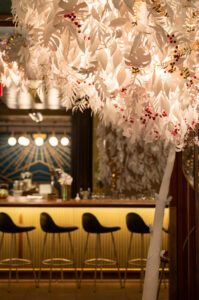 Starbucks interior festooned with white paper decorations of tree branches and leaves