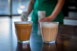 Two small glasses of Starbucks cortado on the counter