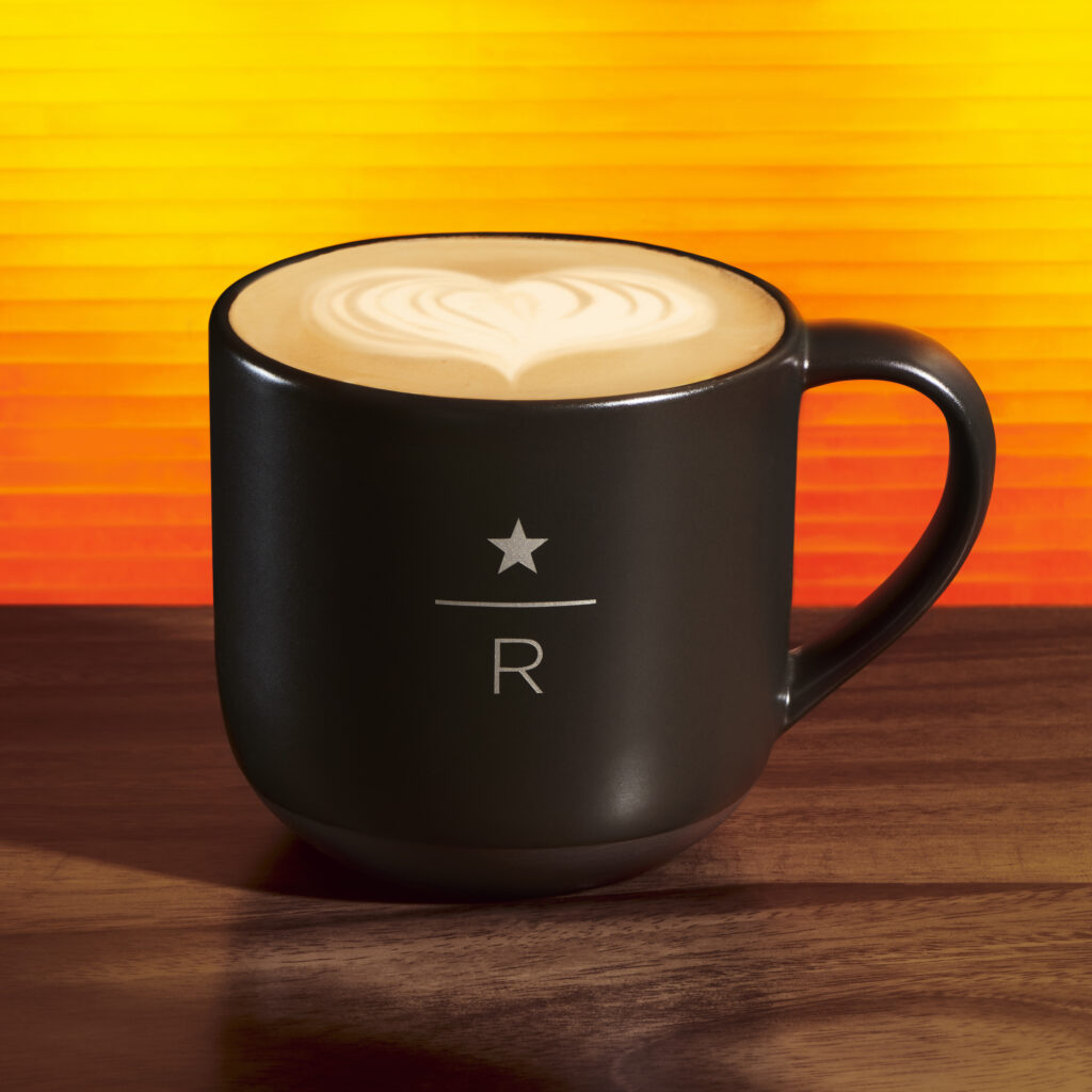Starbucks reserve dirty chai in black mug on an orange background
