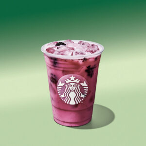 A cup of Starbucks Blackberry Refresher with coconutmilk on a light green background