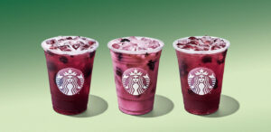 A lineup of Starbucks Blackberry Sage Refreshers on a a light green background