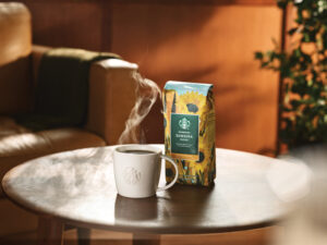 A mug with hot coffee next to Starbucks Sunsera coffee bag