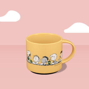 Starbucks and Peanuts yellow mug on a light pink background
