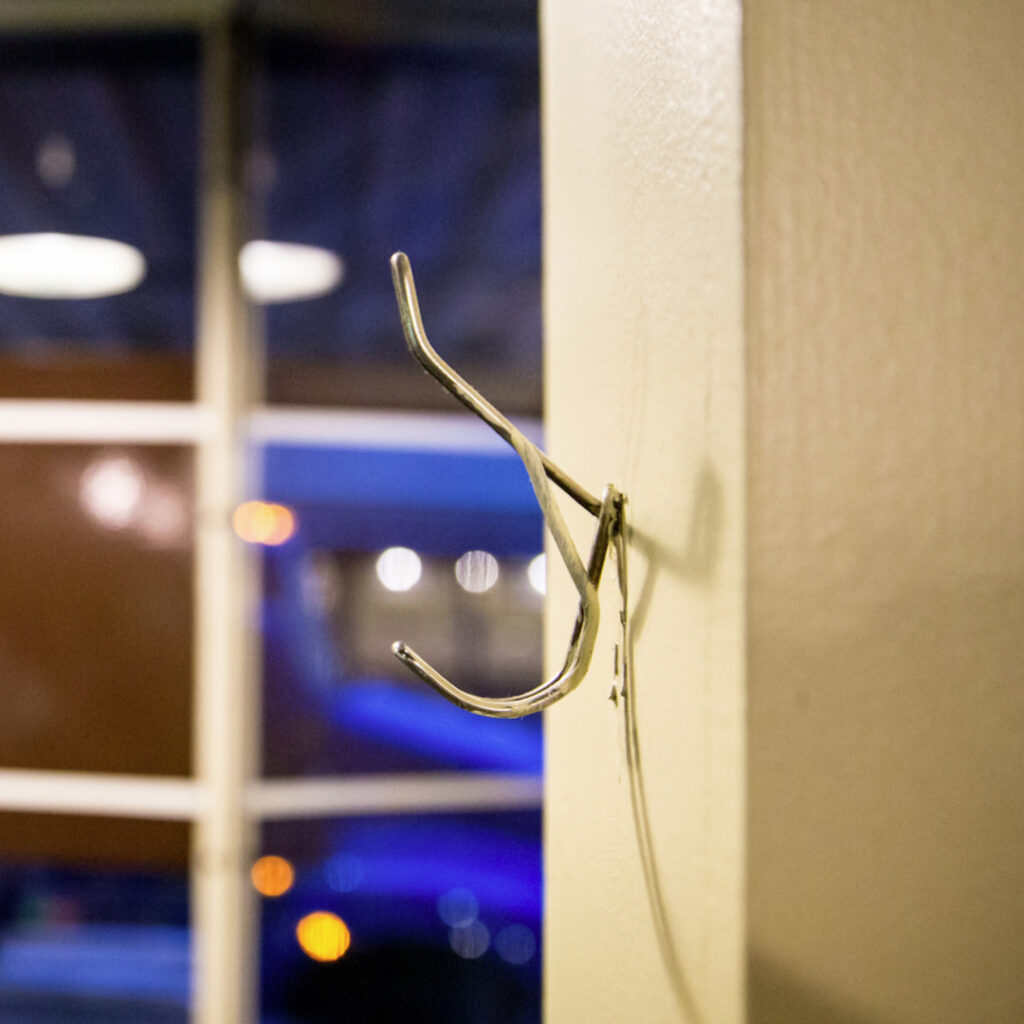 Wall-mounted metal hook.