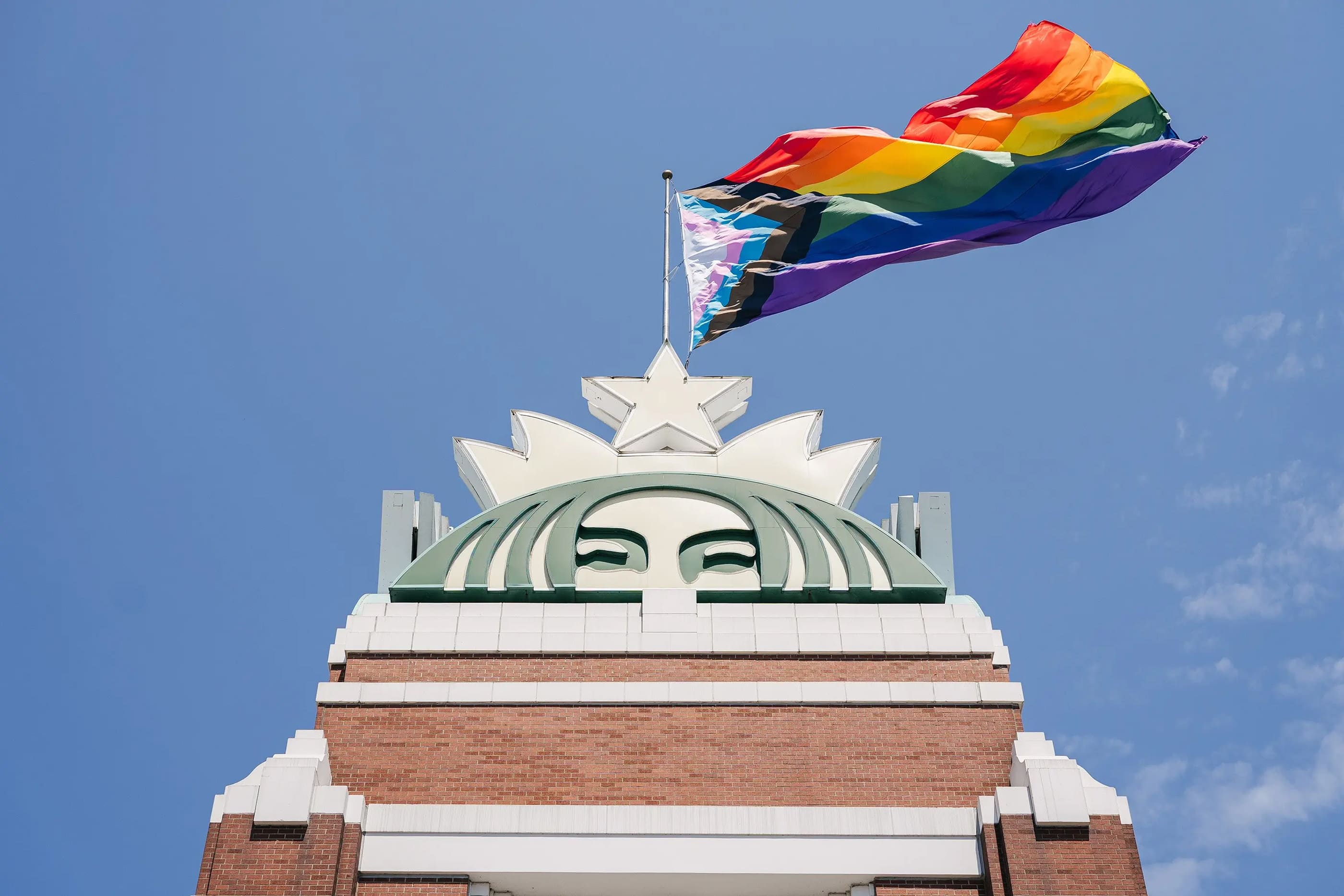 Pride flag waving on top of a Starbucks store